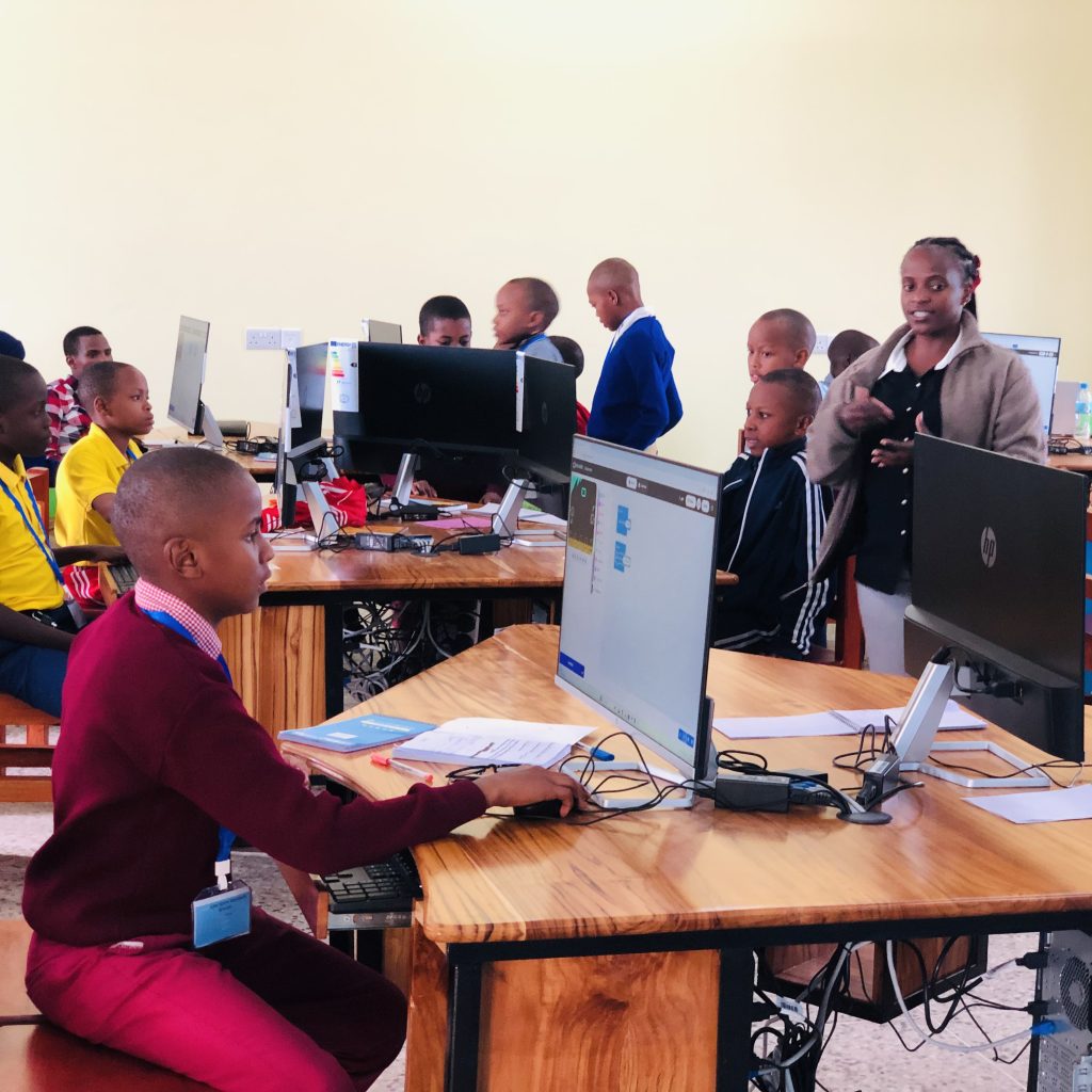Students participating in an EdTech in Tanzania and digital learning session using computers for practical training