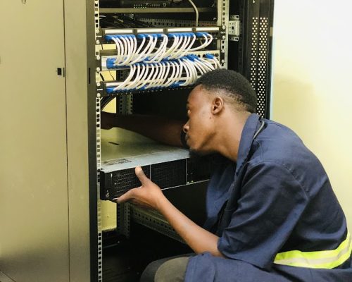 alt="Engineer installing ICT equipment and network infrastructure in Ubora STEM computer laboratory"