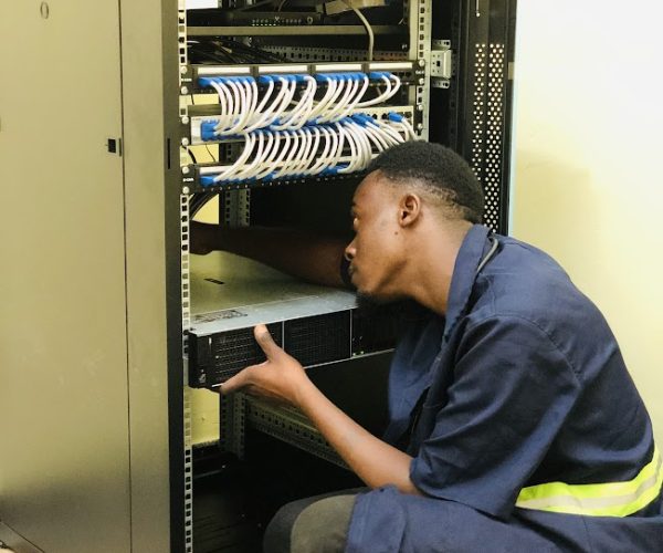 alt="Engineer installing ICT equipment and network infrastructure in Ubora STEM computer laboratory"
